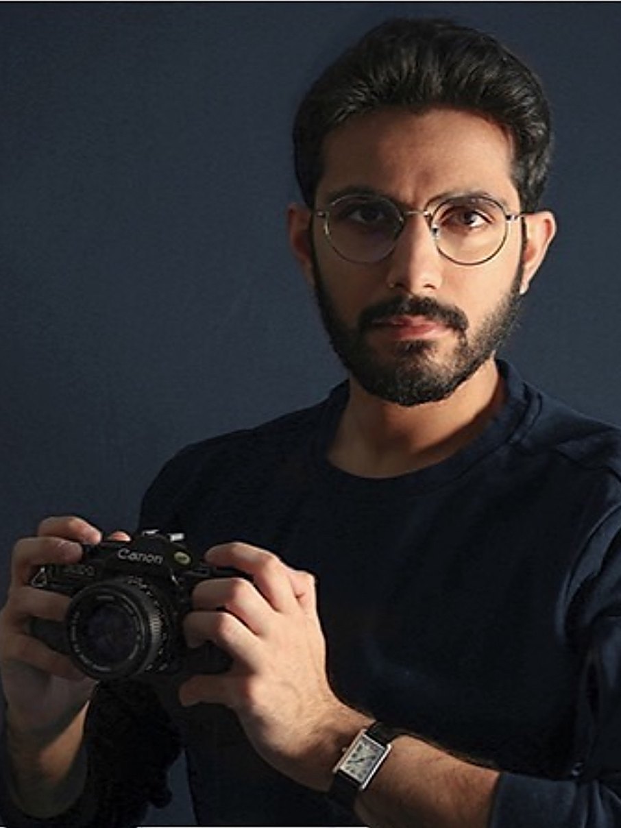 Portrait of Yousef Alamiri holding a Canon film camera